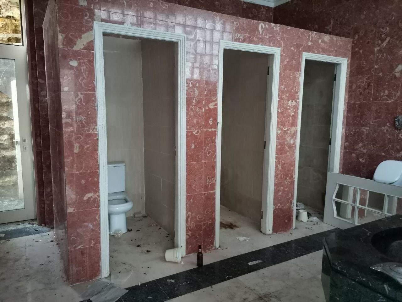 А комната, оказывается, туалетная на много человек. Отсутствием дверей между кабинками она мне напомнила школьные туалеты, только они не были выложены натуральным камнем