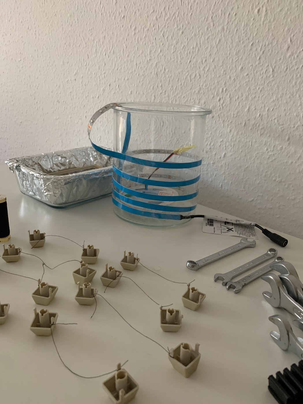 Идея была в вертикальной банке на нитках «взвесить» кнопки, привязав их к гаечным ключам на дне. Нитки путались, ничего не работало. 