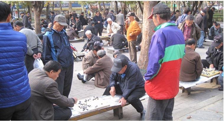 Пенсионеры играют в Го в парке Сеула, Южная Корея